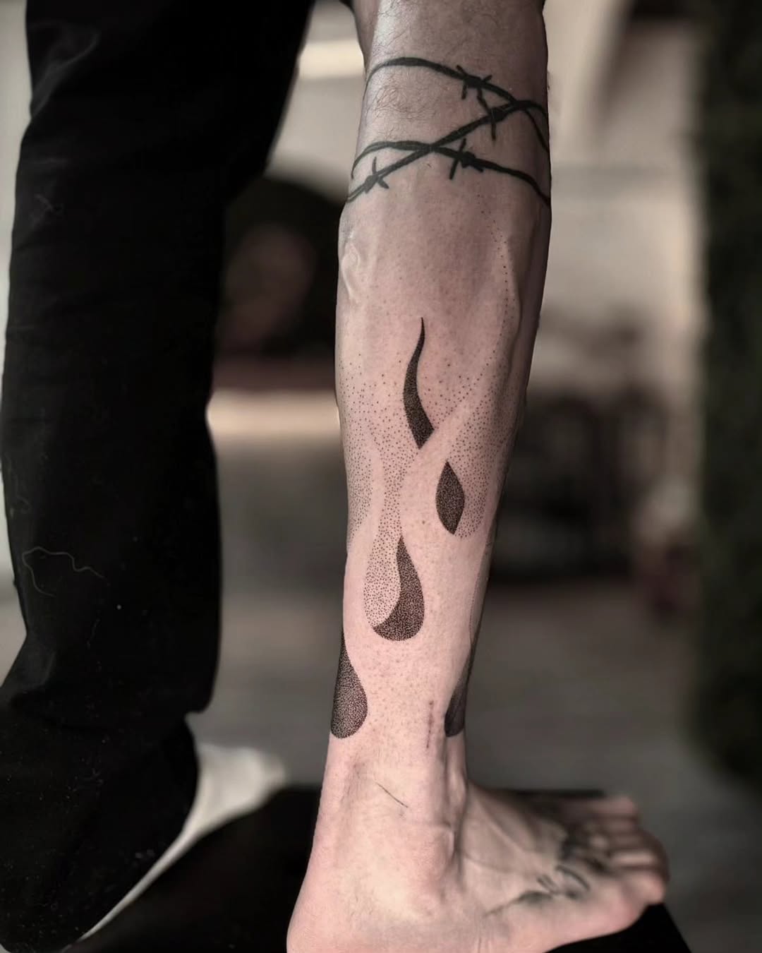 Dotwork plameny na lýtku s ostnatým drátem