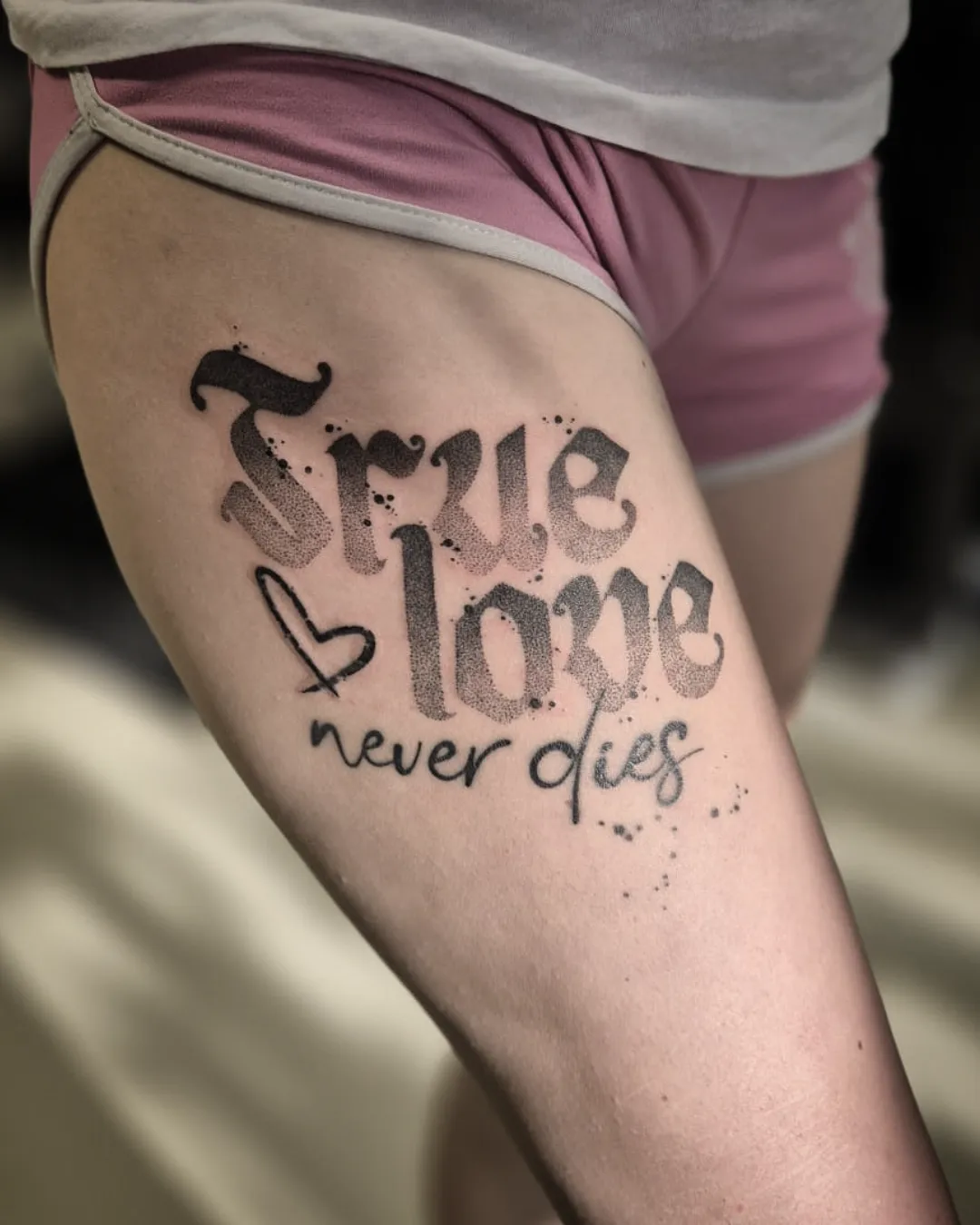 Nápis True Love Never Dies na stehně